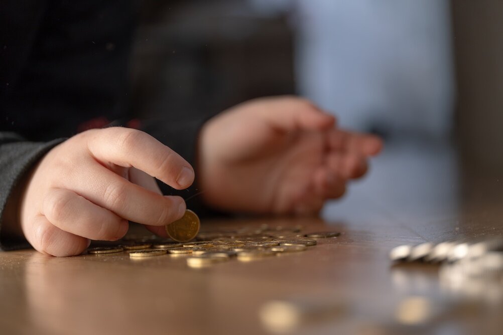 机の上のお金を数えている人の写真