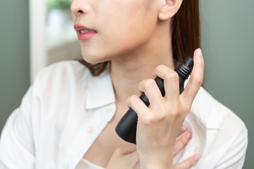 首筋に香水をつける女性
