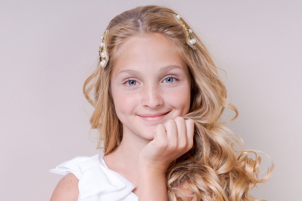 髪を手で顔の近くに持っていっている女の子の写真