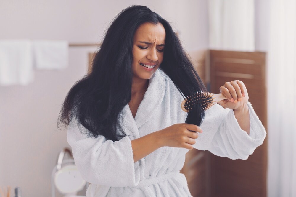 髪をブラシでとかしている時にひっかかっている女性の写真