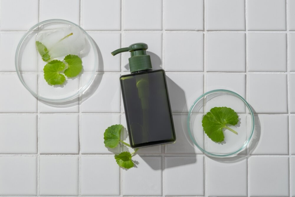 白いタイルの上に植物とシャンプーが乗っている写真