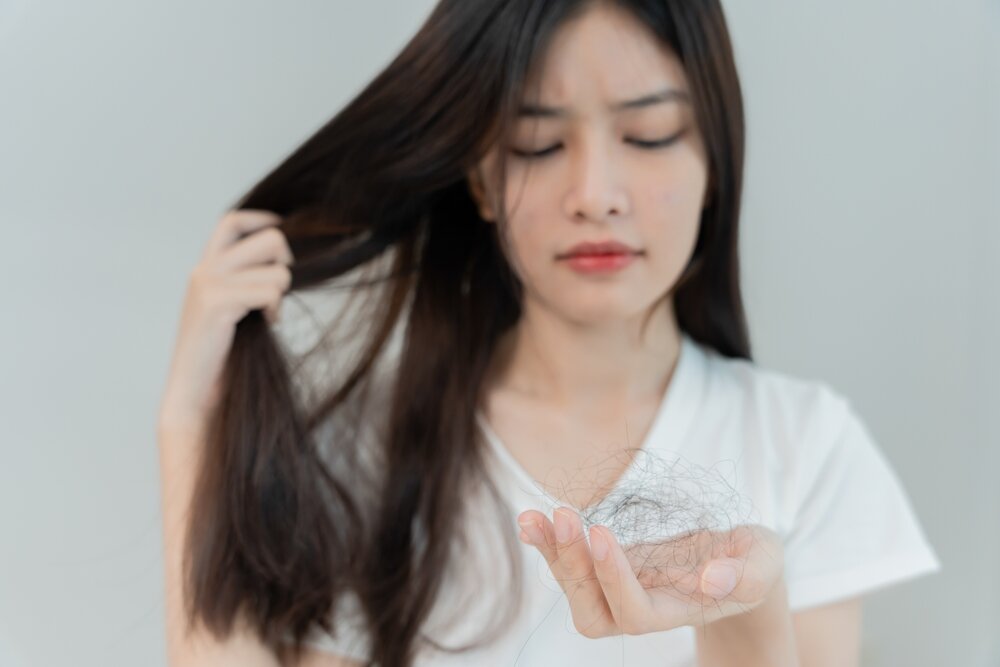 抜けた髪を持っている女性の写真