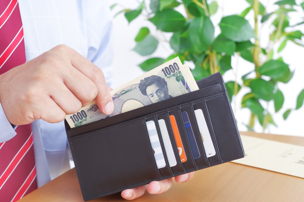 1000円札をお財布から出している人の写真