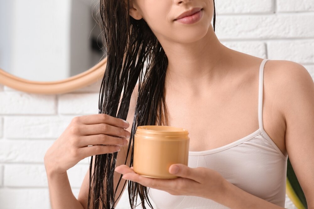 髪にヘアマスクを塗っている女性の写真