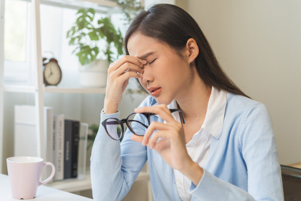 メガネを外し目頭を押さえる女性