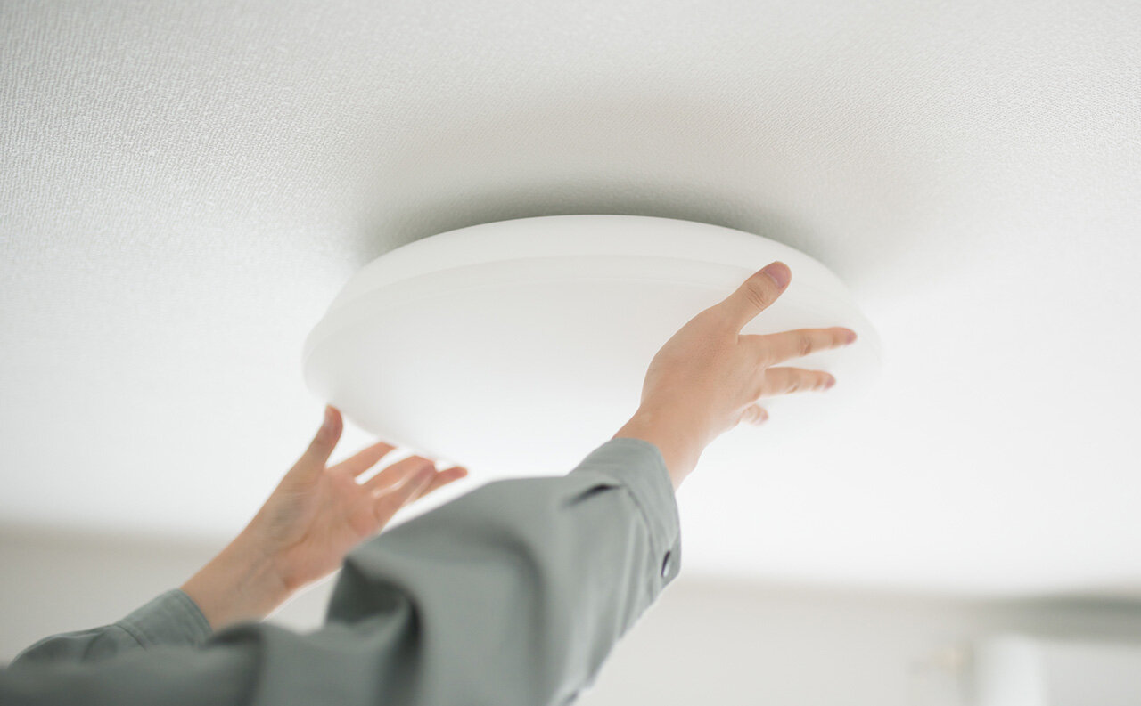 シーリングライトを設置する人